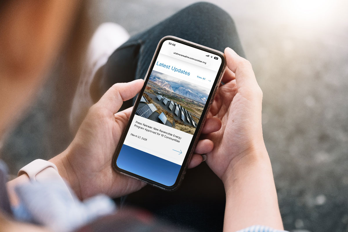 Person looking at their cell phone with Utah Renewable Communities website